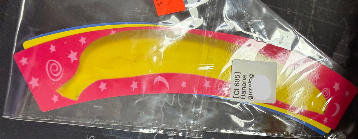 Small banana-shaped object with packaging on a dark surface