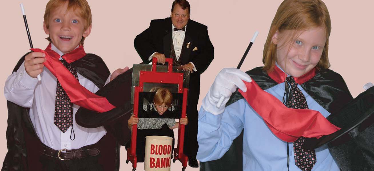 Man in tuxedo with a child behind a screen labeled 'Blood Bank' on a stage.