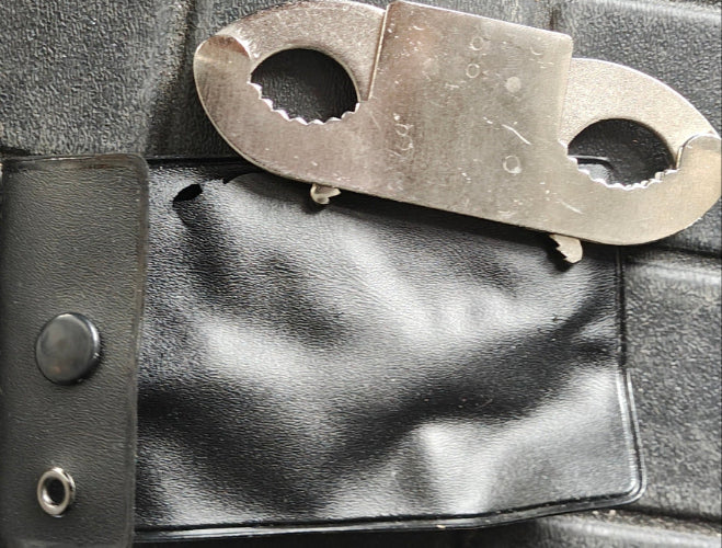 Metal Thumb cuffs on a black leather pouch