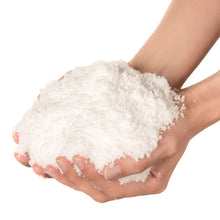 Hand holding a large scoop of white powder against a white background