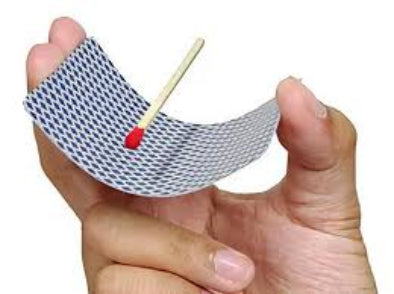 Hand holding a small woven boat made of metal wire with a matchstick sail.