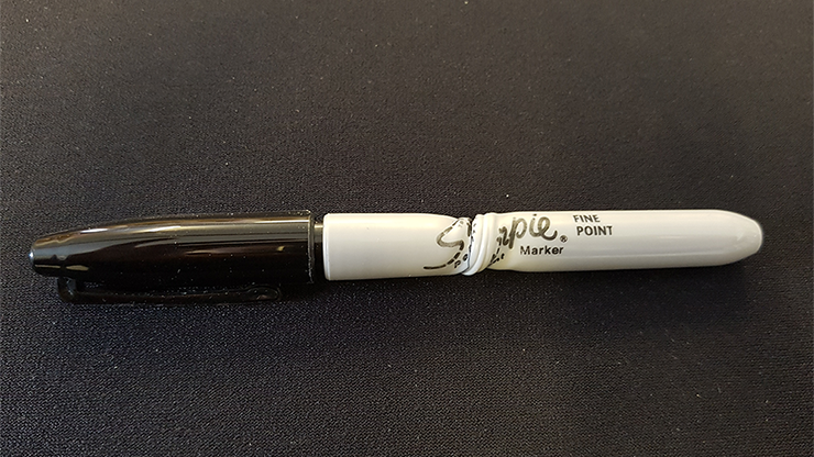 Black marker with white cap on a black background