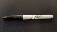 Black marker with white cap on a black background