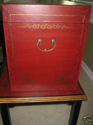 Red leather-bound box with gold embossing on a wooden surface