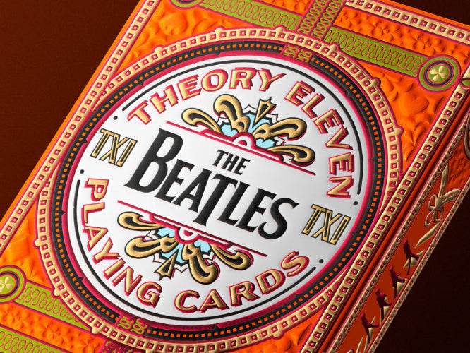 The Beatles playing cards with decorative border on a brown background