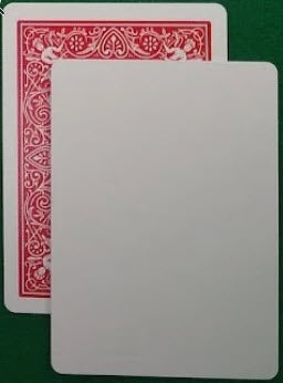 Two playing cards, one red and one white, on a green surface.