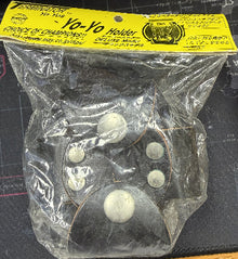 Vintage yo-yo holder with plastic packaging on a dark background