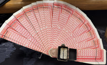 Fanned-out deck of cards with a black box on a dark surface