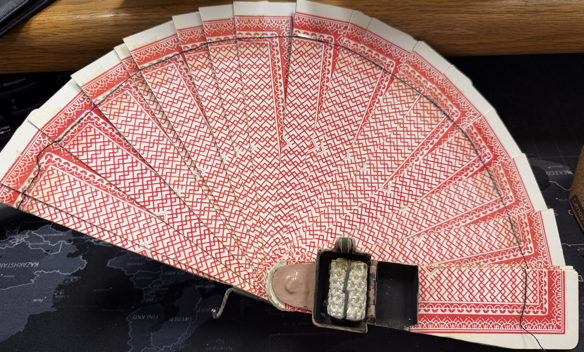 Fanned-out deck of cards with a black box on a dark surface