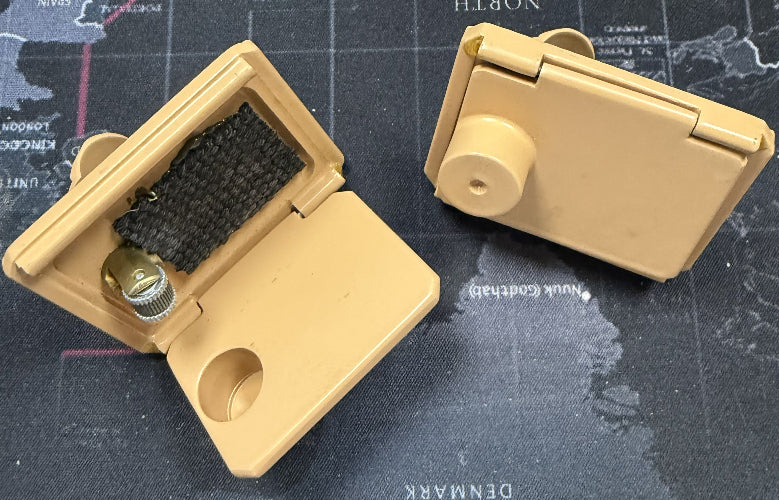 Beige metal box with a brush and cap on a map background