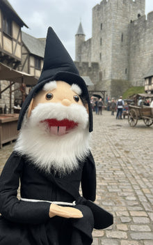Toy figure of a character with a beard and black coat sitting on a desk.