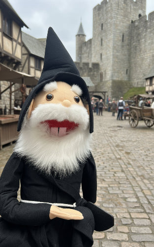 Toy figure of a character with a beard and black coat sitting on a desk.