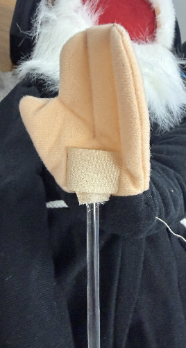 Beige cleaning brush with a long handle against a dark background