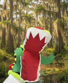 Colorful felt dinosaur toy on a wooden chair