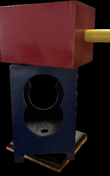 Red and blue wooden block with a circular hole on a wooden surface