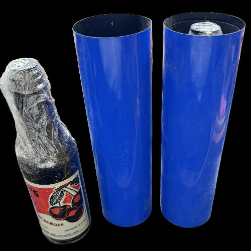 Two blue rolls of vinyl wrap next to a bottle with cellophane on a cluttered surface.