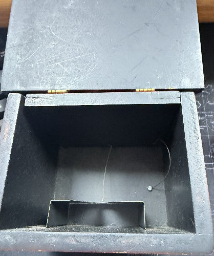 Black wooden box with a compartment on a dark surface