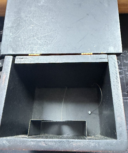 Black wooden box with a compartment on a dark surface