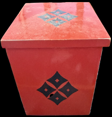 Red box with black geometric design on a dark surface