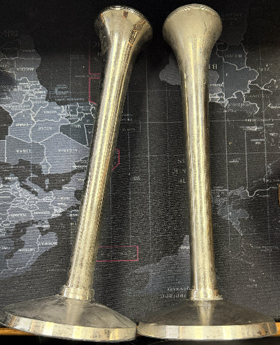 Two brass trumpet mouthpieces on a map background