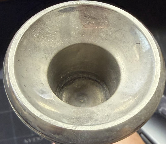 Metallic cylindrical object with a worn interior