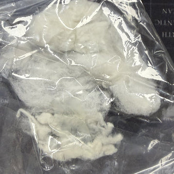 White powdery substance in a clear plastic bag on a dark surface with text