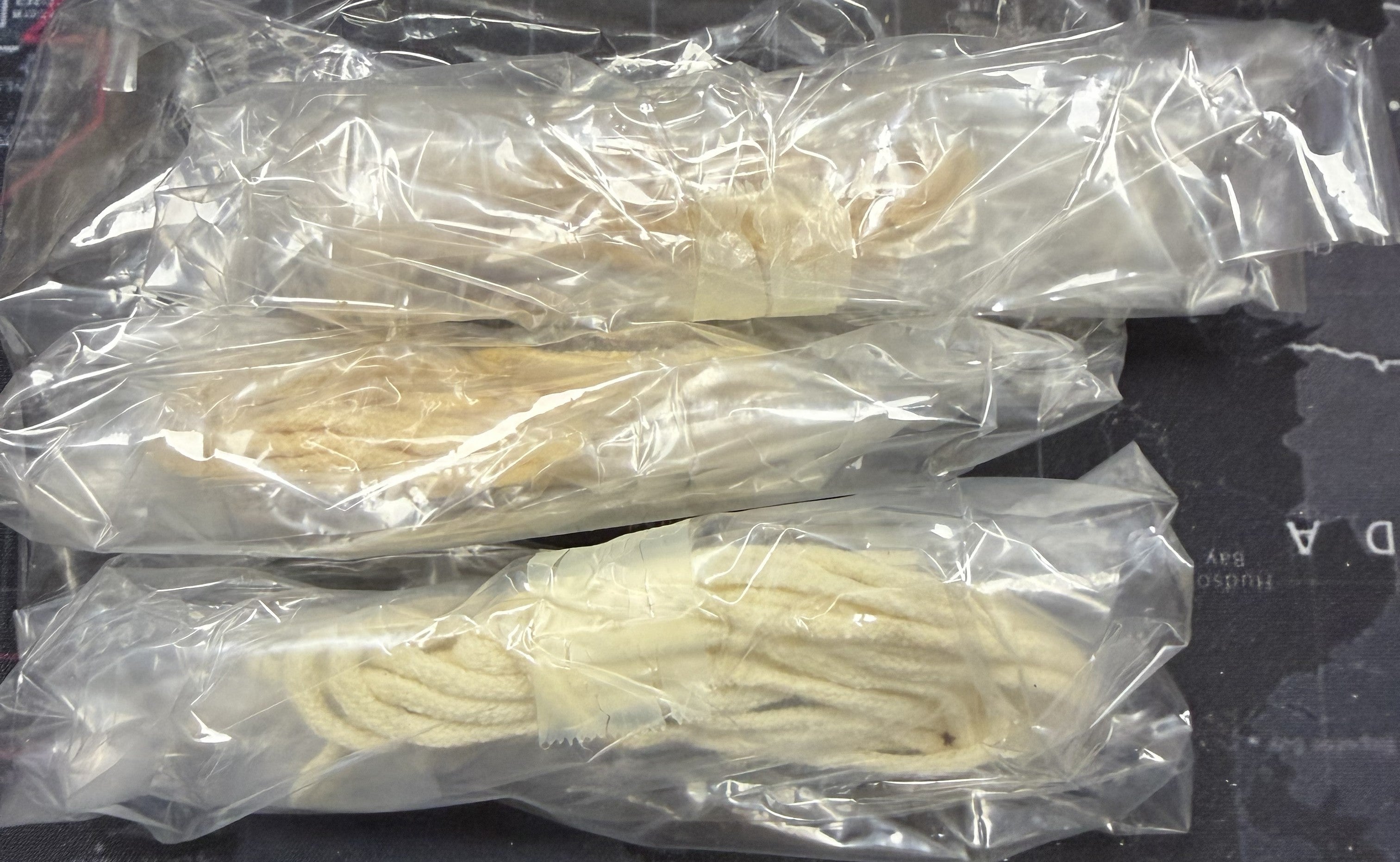 Two packages of white noodles on a dark surface