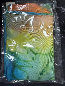 Colorful fabric with a tie-dye pattern in blue, green, and orange on a clear plastic bag.