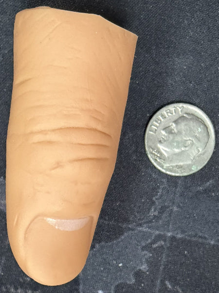 Large artificial finger next to a quarter on a dark textured background