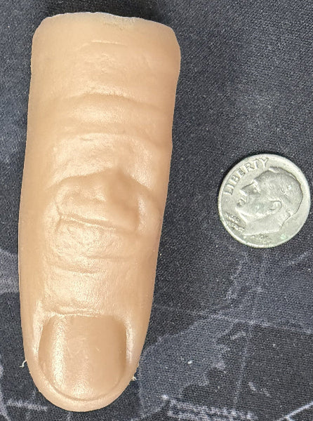 False finger next to a coin on a textured surface