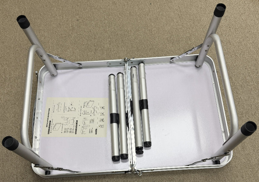 Metallic folding chair with a white cushion on a beige background