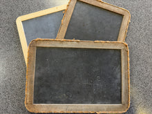 Three vintage-style blackboards with wooden frames on a textured surface