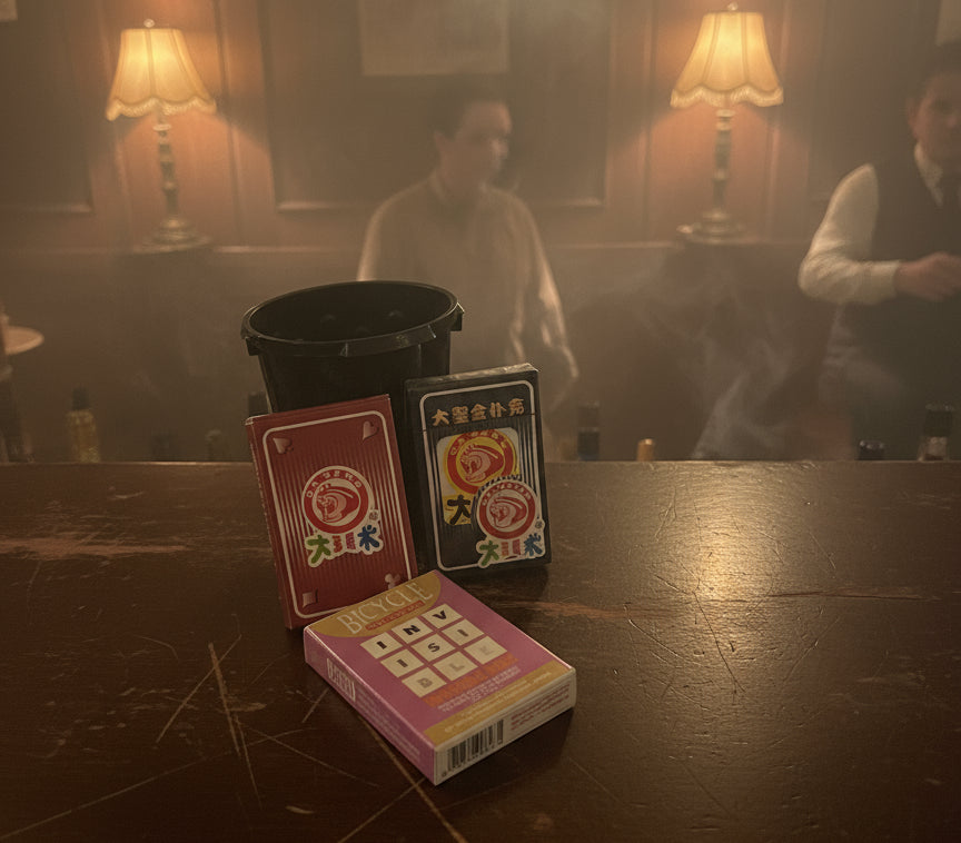 Two playing card decks with colorful designs on a gray surface.