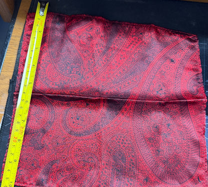 Red paisley fabric with a measuring tape on a black surface