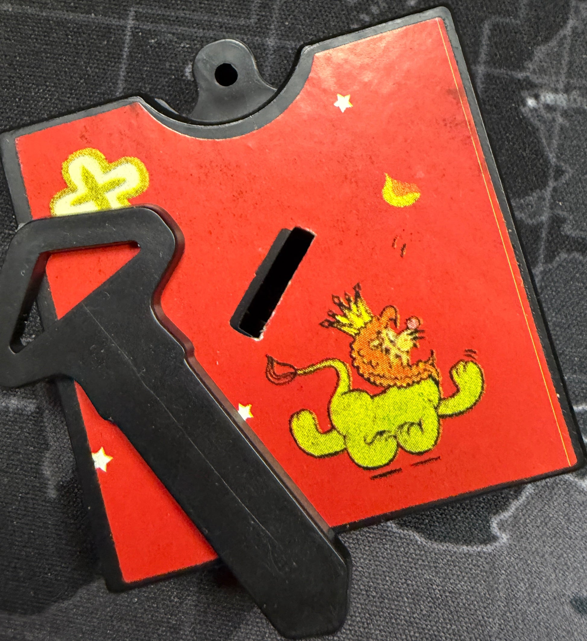 Red tool with a green frog design on a camouflage background