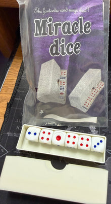 Packaged Miracle Dice with dice set on a desk