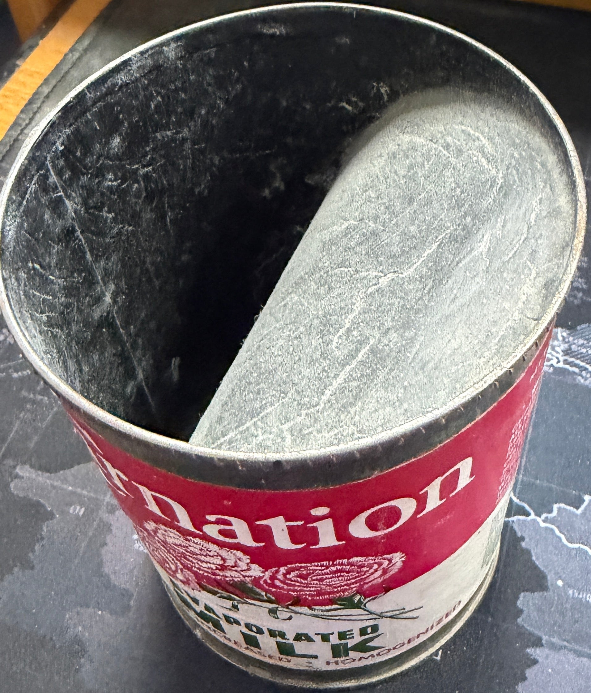 Metal can with red label on a textured surface