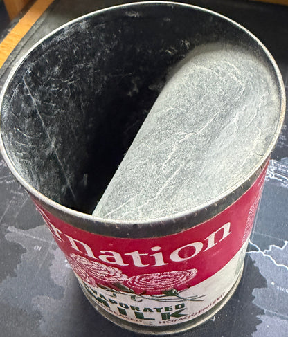 Metal can with red label on a textured surface