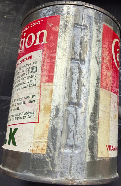 Metal canister with a decorative label on a dark surface