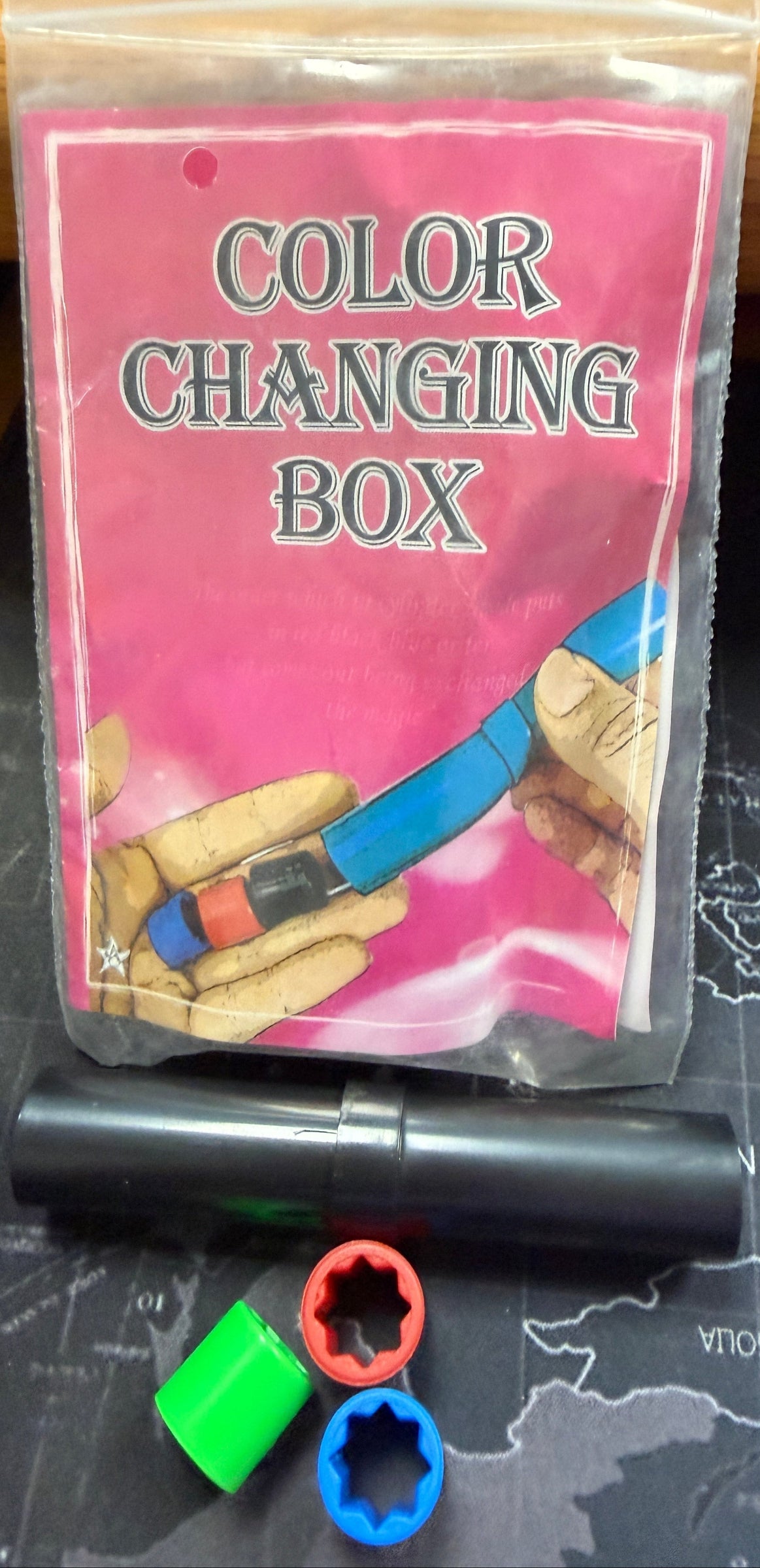 Color changing box with a pen and colorful caps on a map background