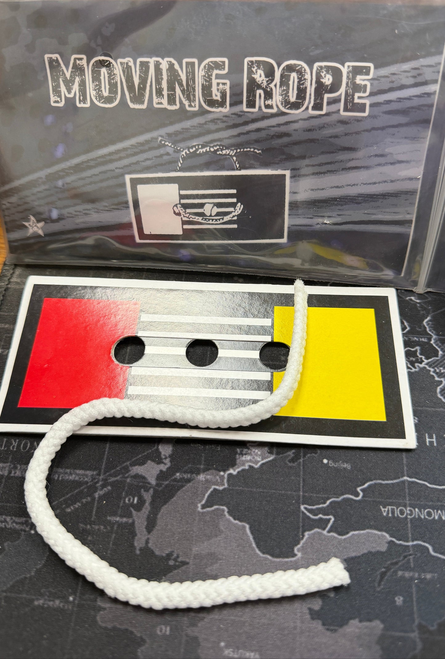 White rope with a red and yellow card on a map background