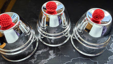 Three glass jars with metal lids and red crochet covers on a map surface.