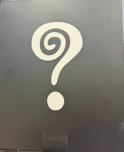 Black box with a white spiral design on a wooden surface