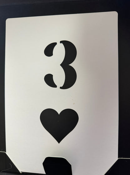 Stencils of a mustache and a heart on a white card with black border