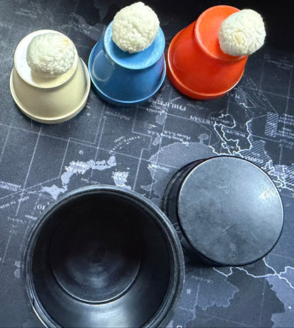 Colorful cups with white spherical objects on a world map surface