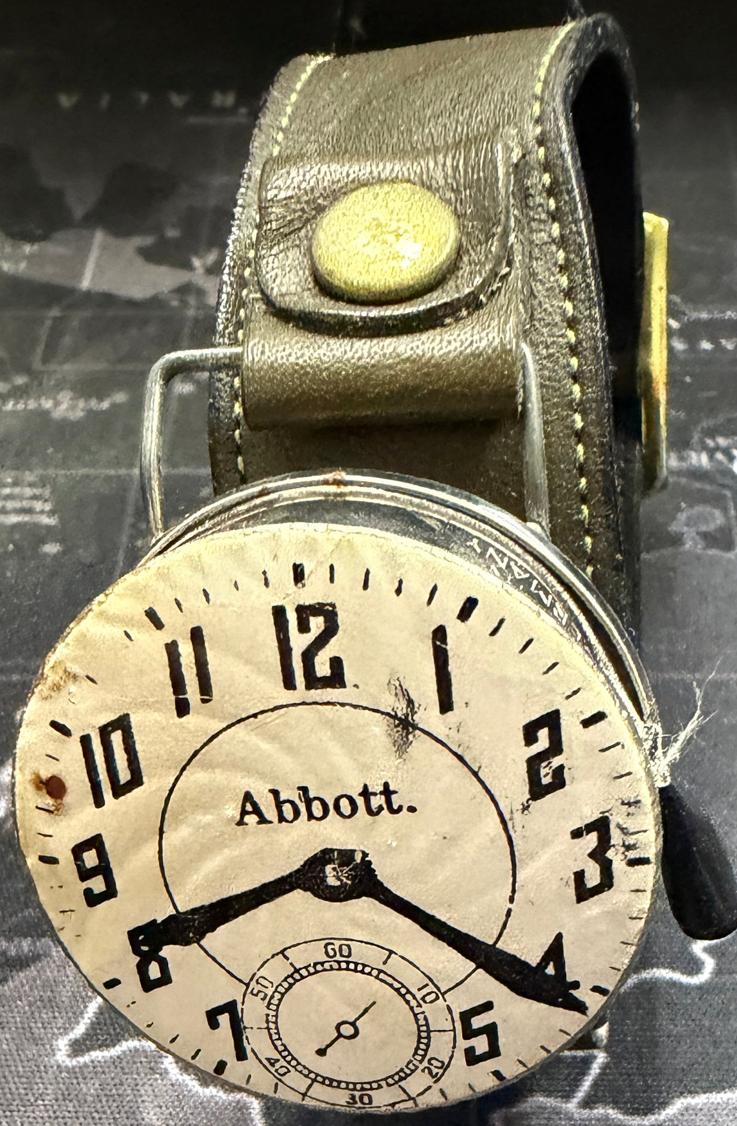 Vintage-style wristwatch with leather strap on a map background