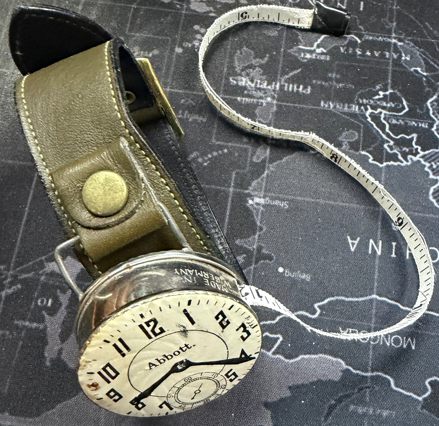 Vintage-style measuring tape on a world map background