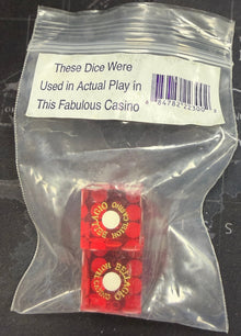 Two red dice in a clear plastic bag with a label on a map background