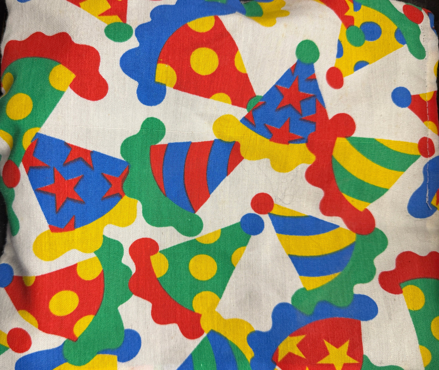 Colorful pillow with clown hat pattern on a dark background