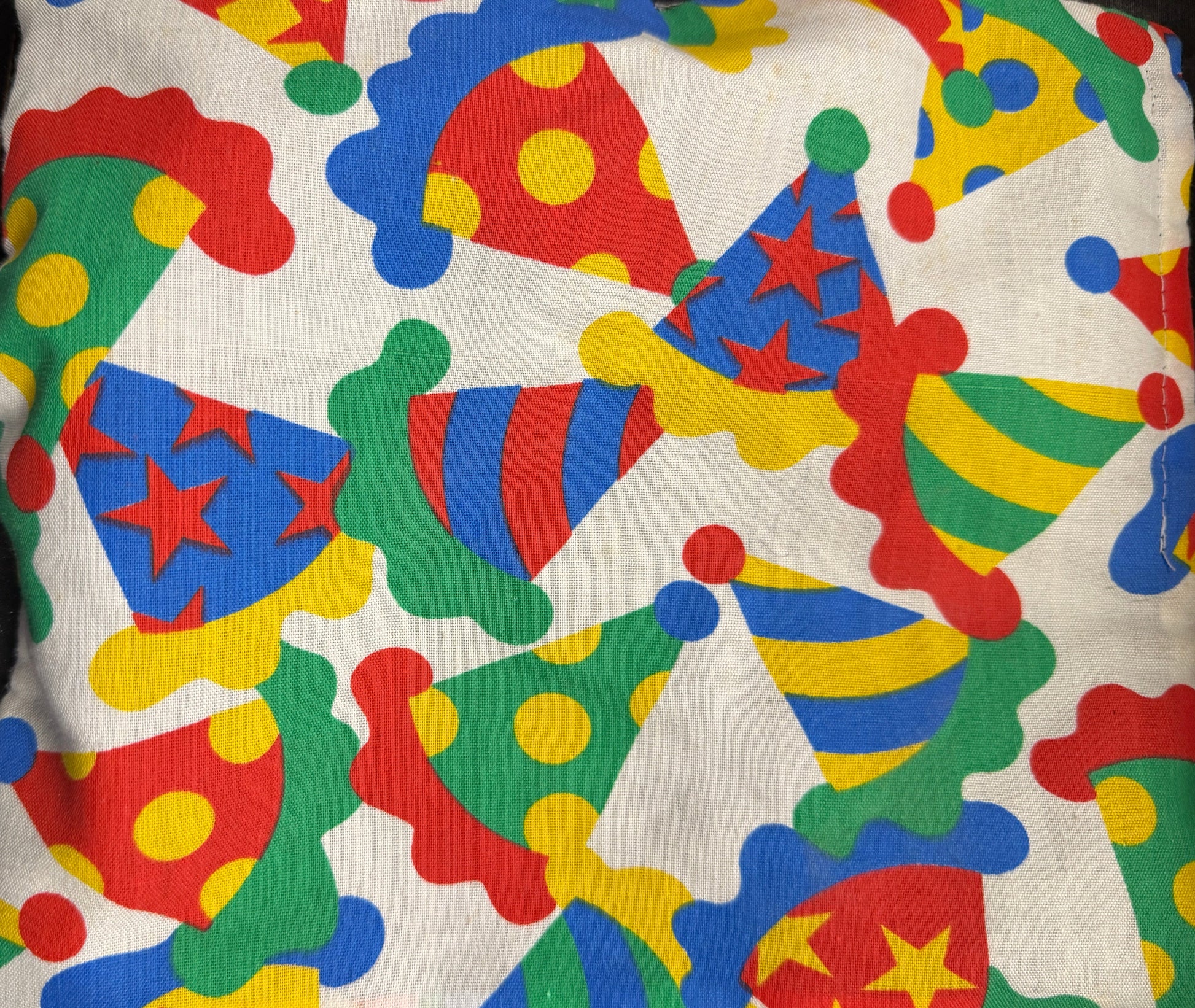 Colorful pillow with clown hat pattern on a dark background